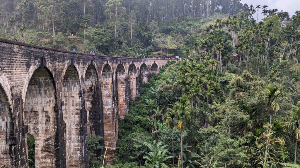 View of Nine Arches Bridge in Ella from the side with the tea plantations below it.