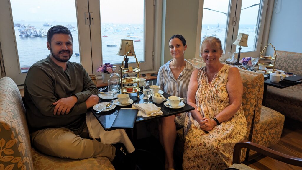 Three people sitting at a table at Taj Palace Hotel's Sea Lounge for High Tea. This is a top thing to do when visiting Mumbai.