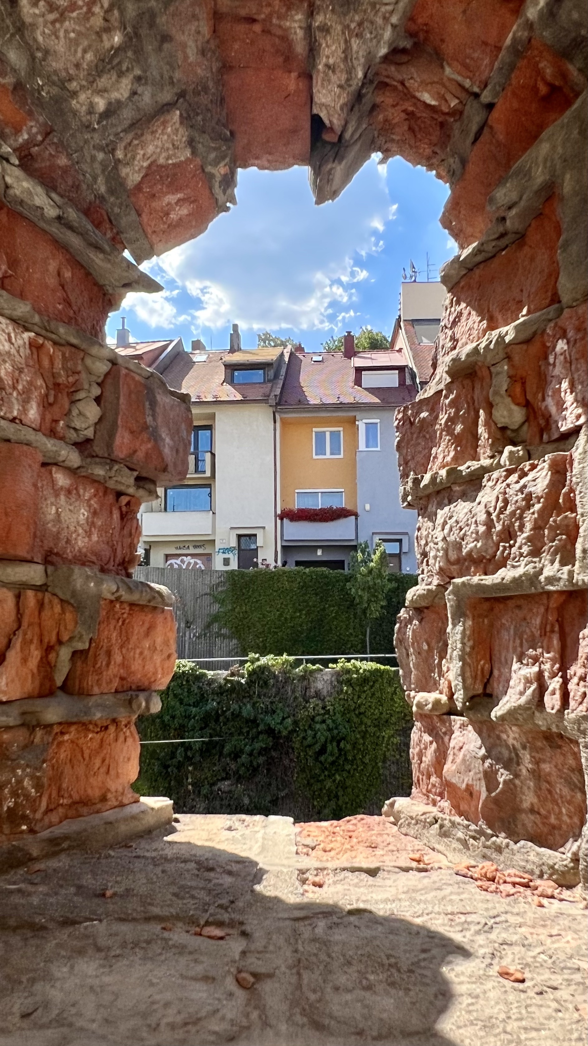 View of homes through hole in the city walls in Bratislava