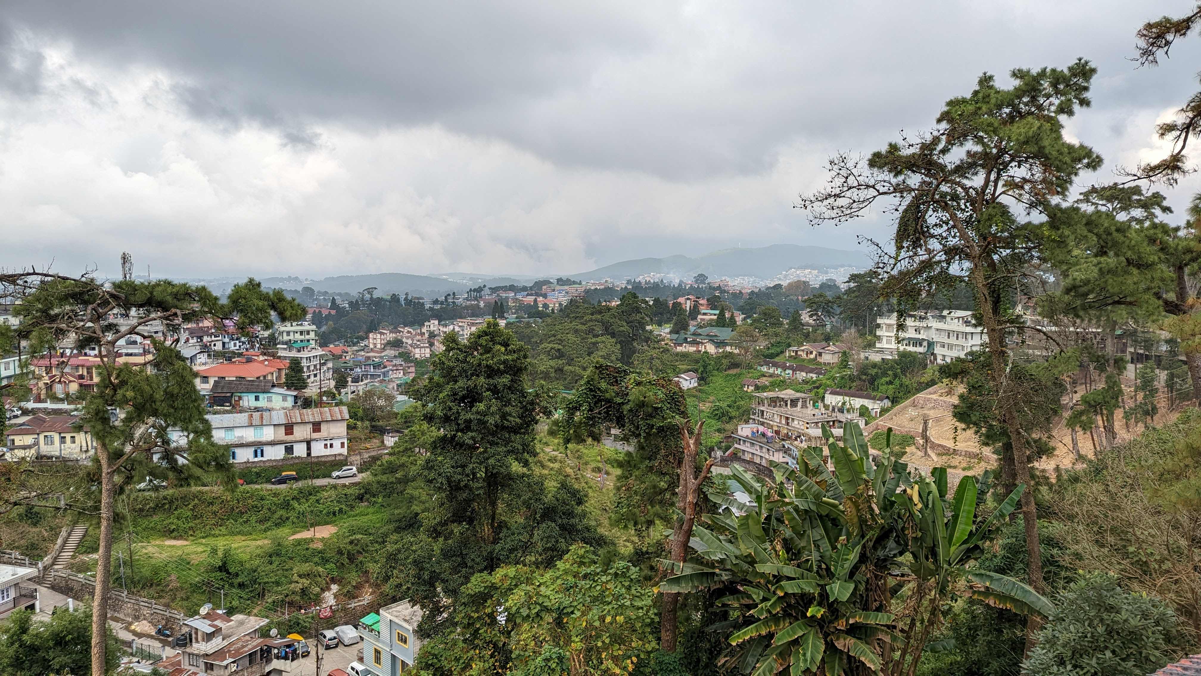 View of the rolling landscape of Shillong including buildings and trees from the deck at Heritage Club.