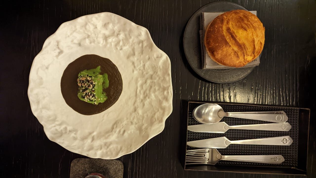 Overhead view of main course dish, bread, and cutlery at Masque Mumbai, India's best restaurant.