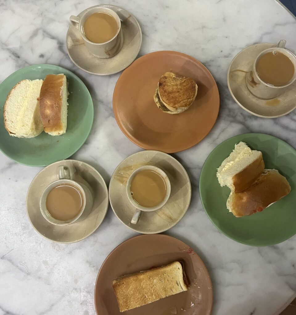 Overhead view of a table with cups of chai and bum maska at Cafe Sassanian in Mumbai.