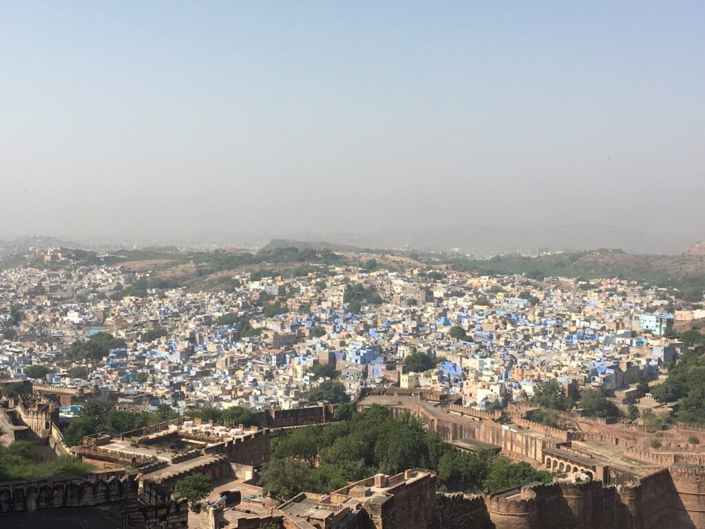 A panoramic view of Jodhpur from Mehrangarh Fort that includes the fort in the forefront and the city's buildings beyond it.