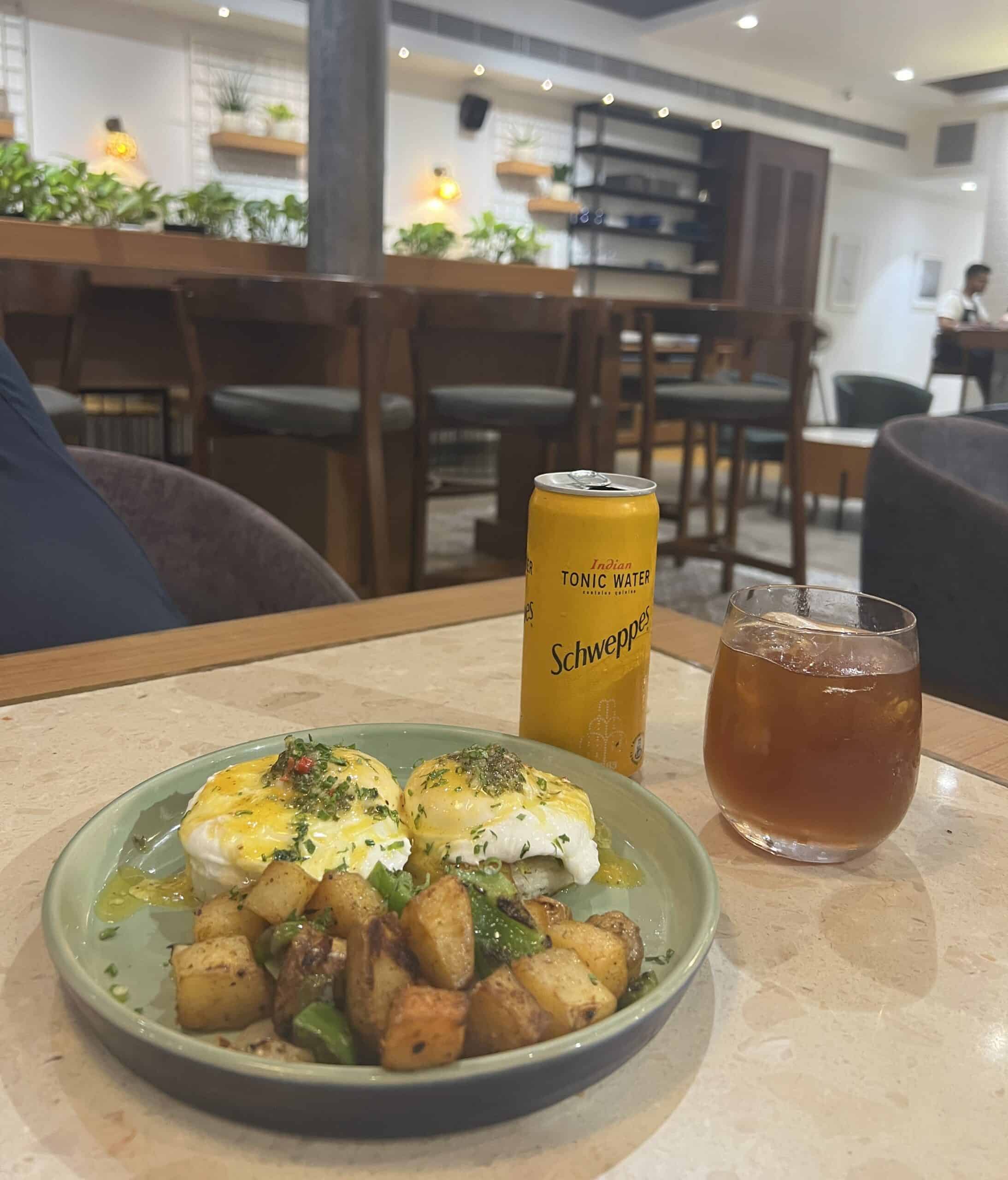 A plate of eggs, breakfast potatoes and a cup of coffee on a table at Kuckeliku Breakfast House in Mumbai. 