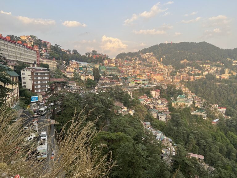 View of buildings built into the side of a mountainous landscape in Shimla, India