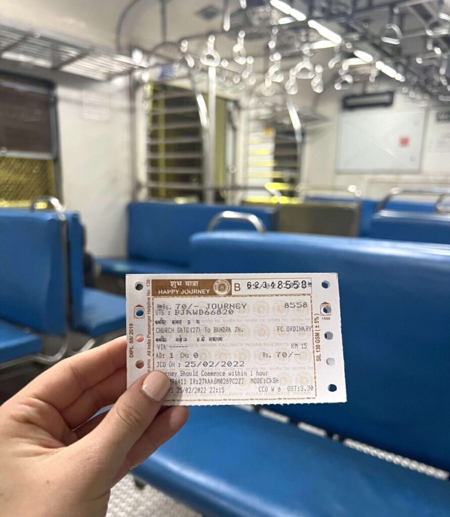 Girl's hand holding a local train ticket in an empty train car on a Mumbai Local Train.