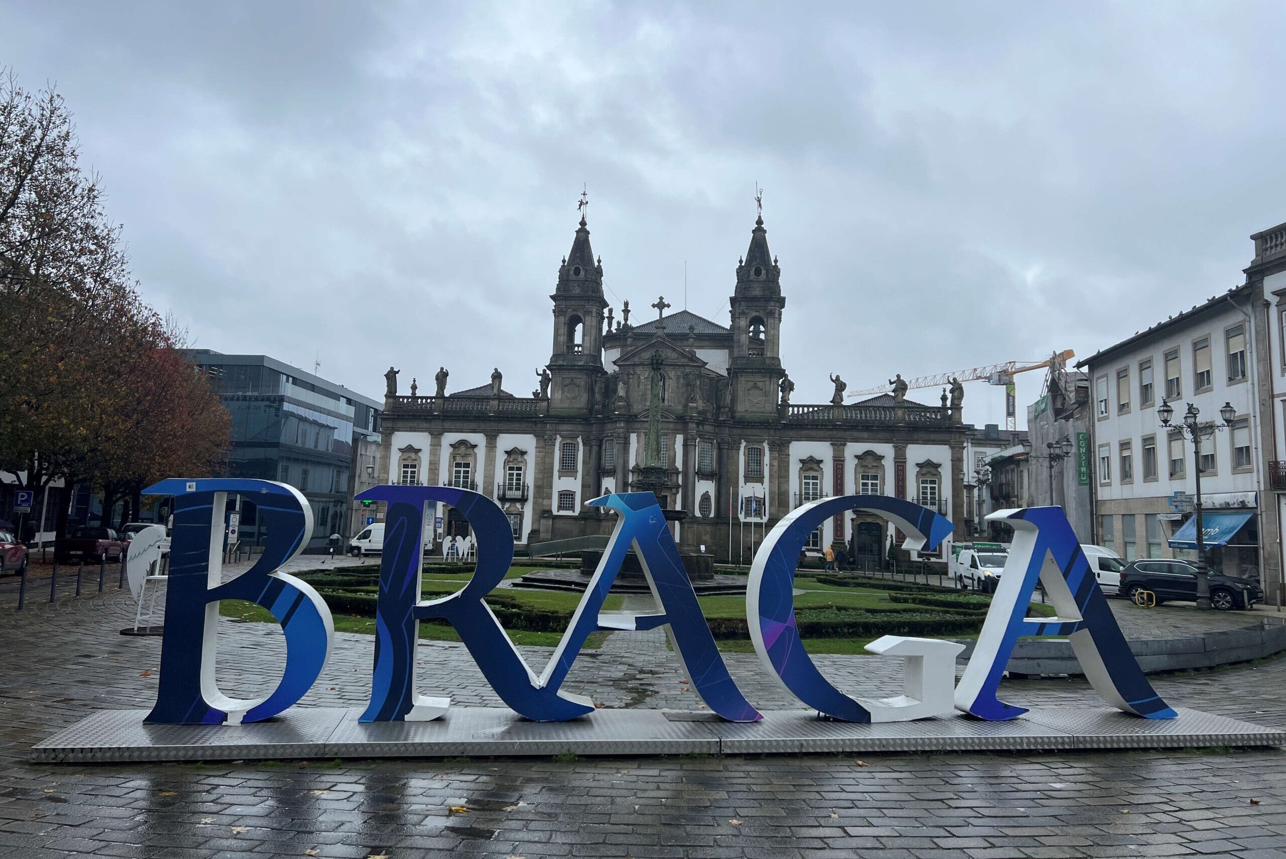 Big standing letters spelling out Braga in the middle of square in front of an ornate church.