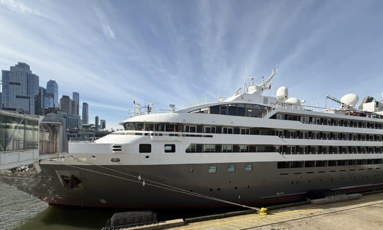 Ponant’s L’Austral cruise ship docked in Manhattan, with balcony staterooms and the New York City skyline in view.